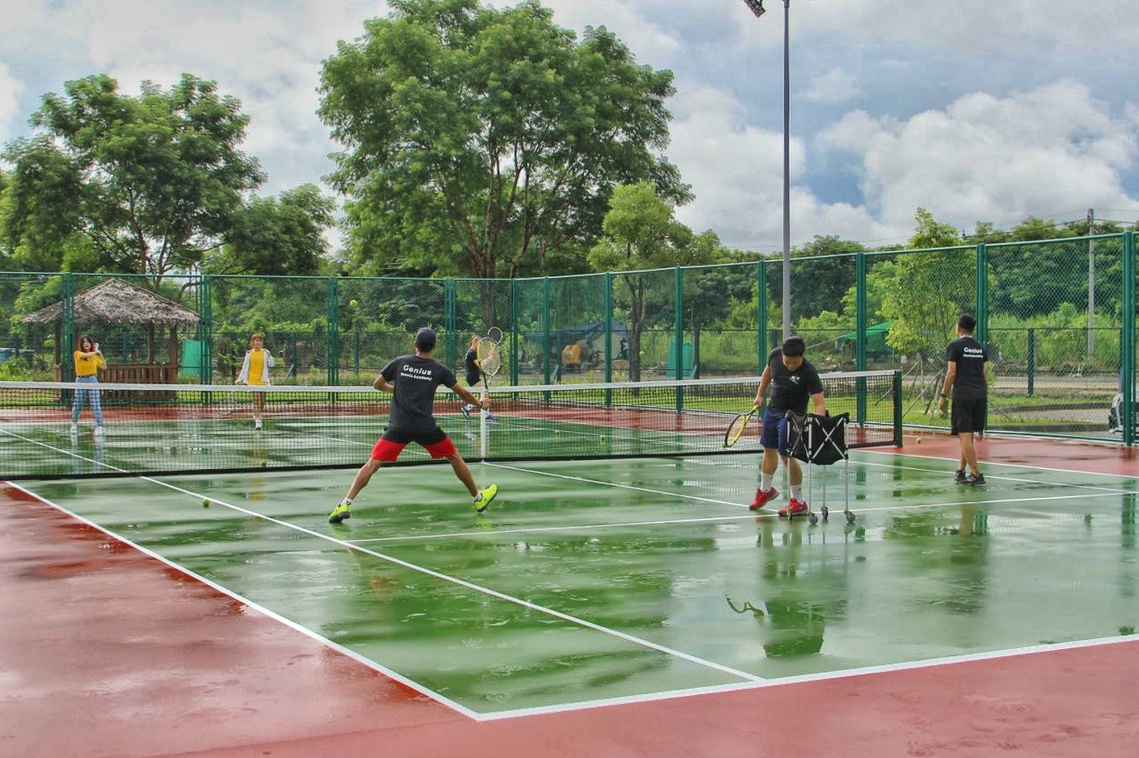 a group of people playing tennis