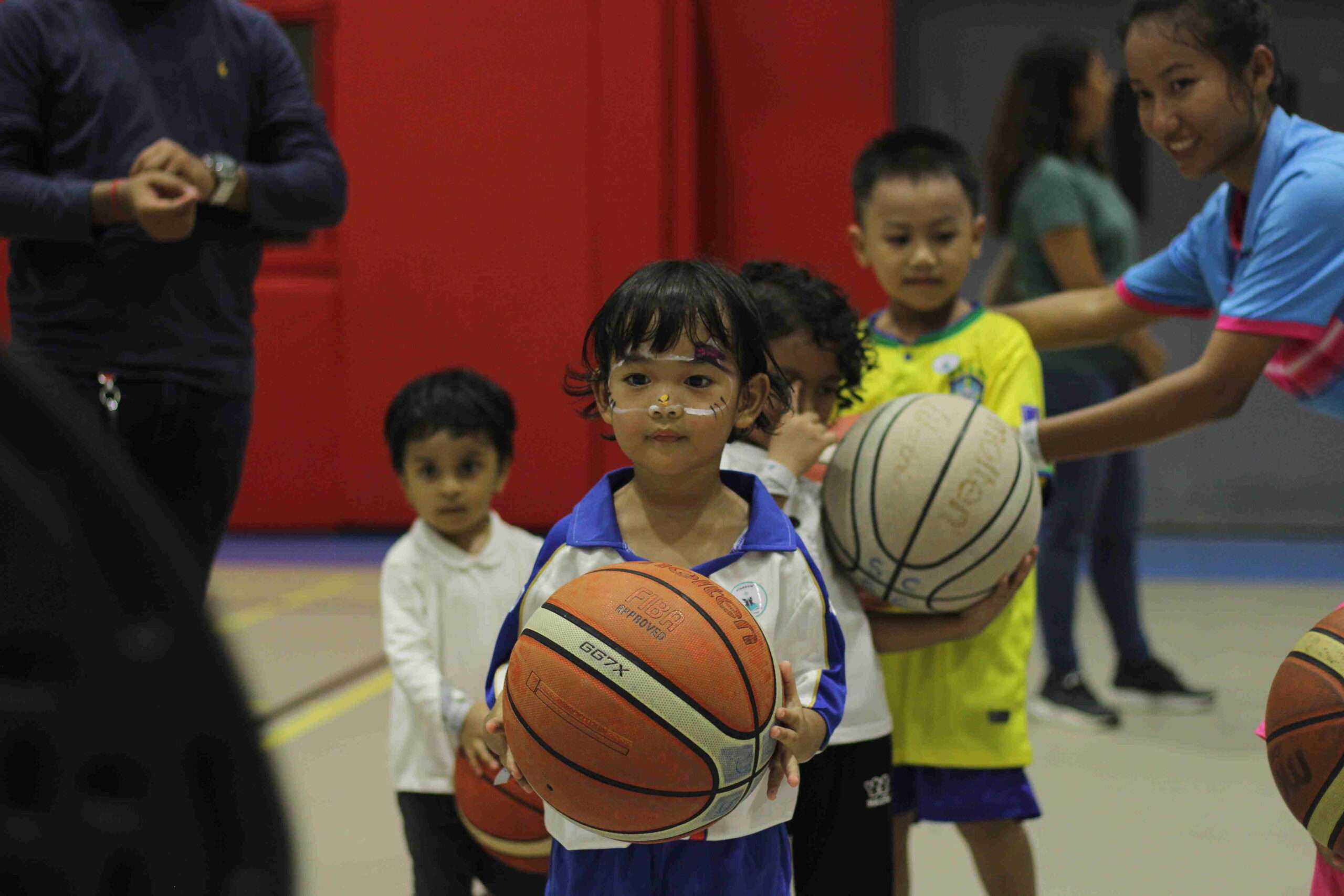 a group of children holding basketballs