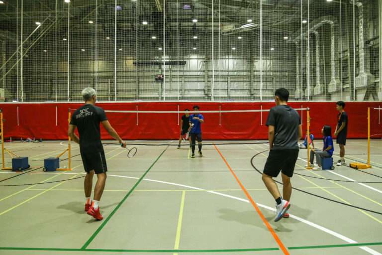 a group of people playing badminton