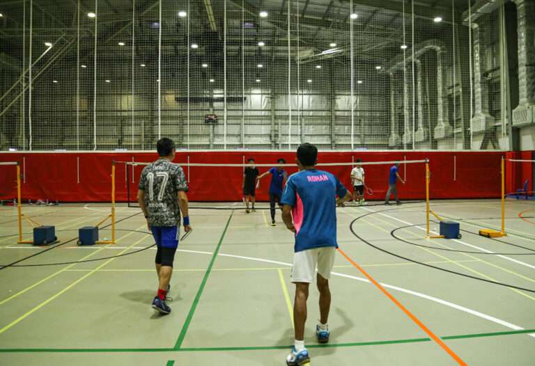 a group of people playing badminton