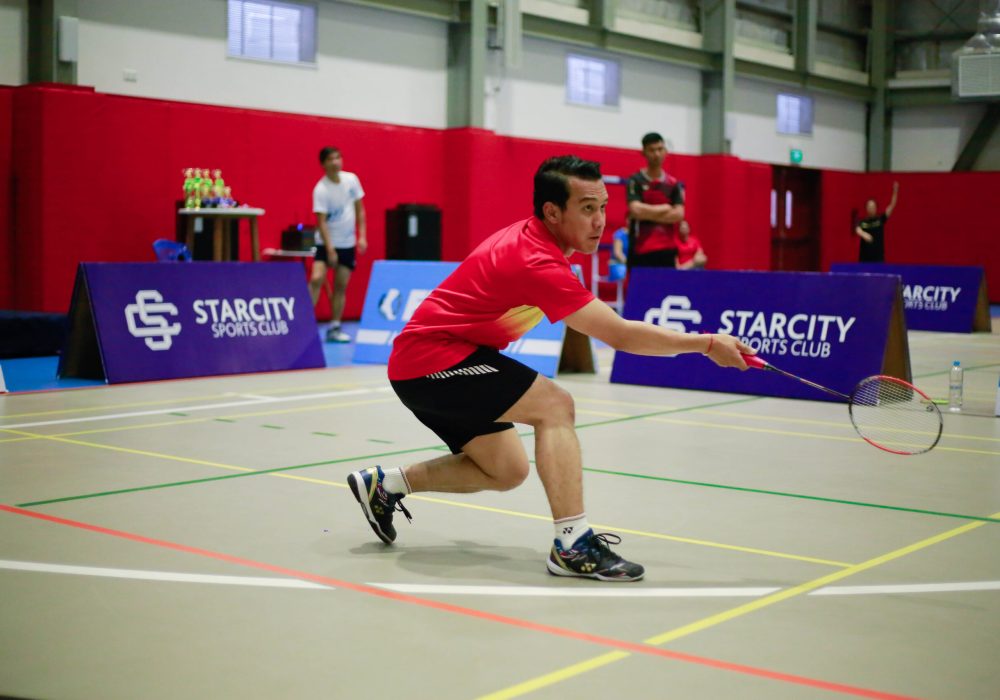 a man playing badminton in a tournament