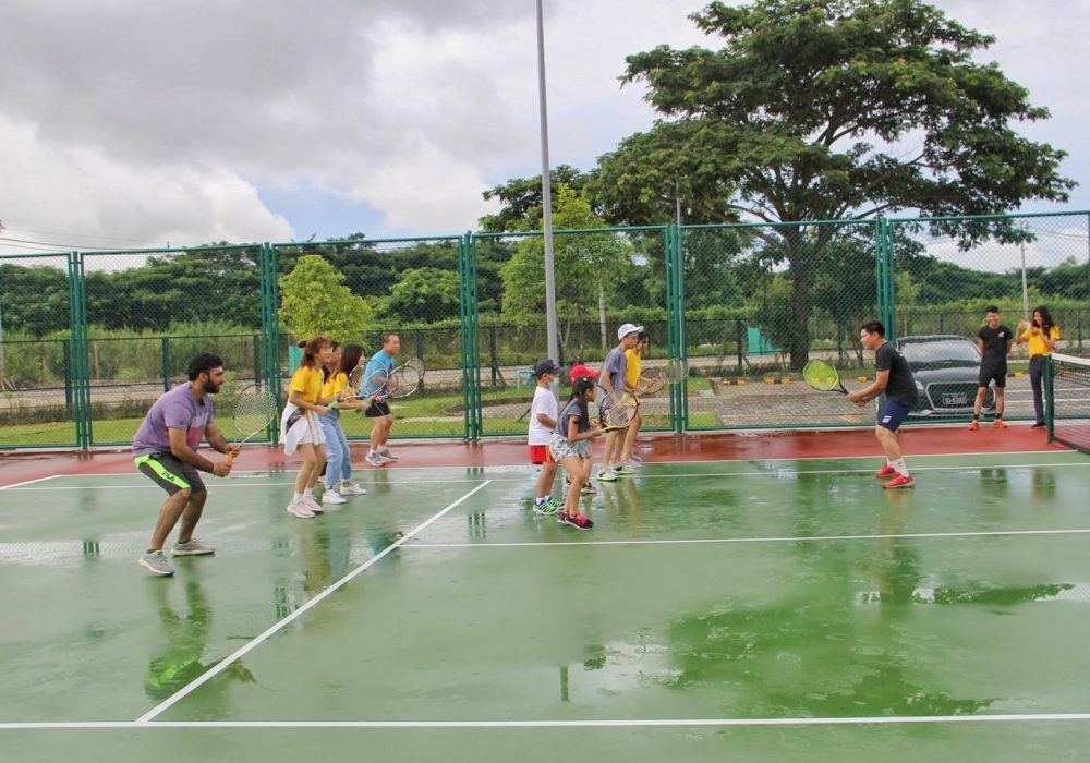 a group of people training tennis