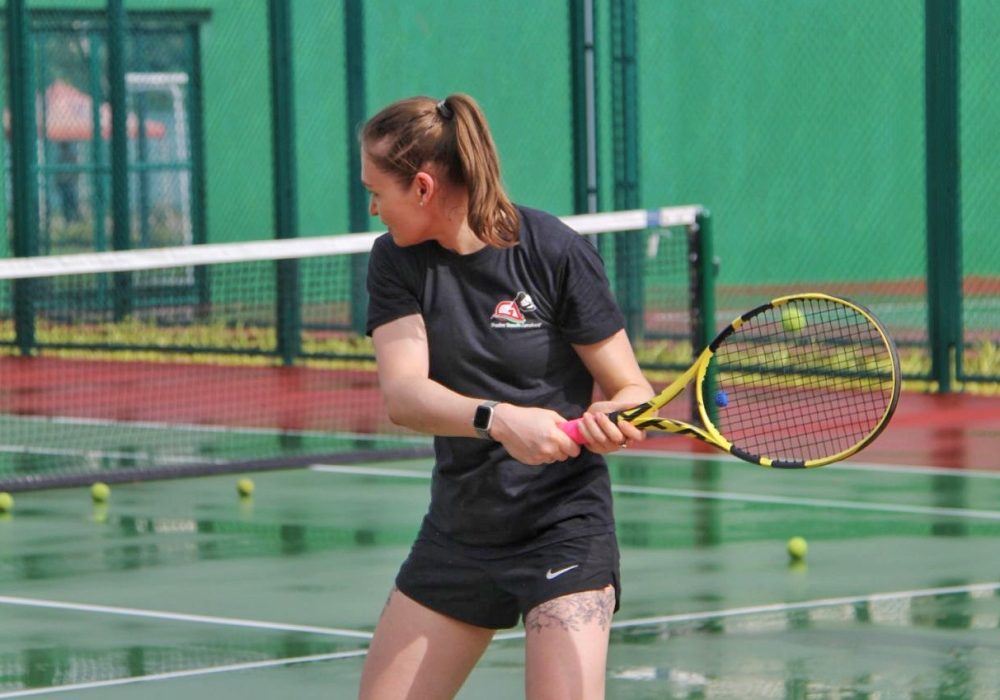 a women holding a tennis racket