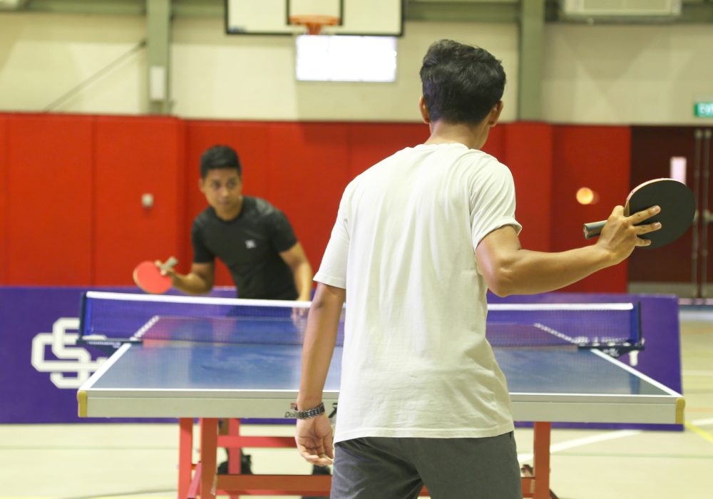 two people playing table tennis